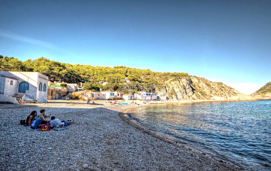 Las casitas de pescadores de puertas azules en la orilla de la cala